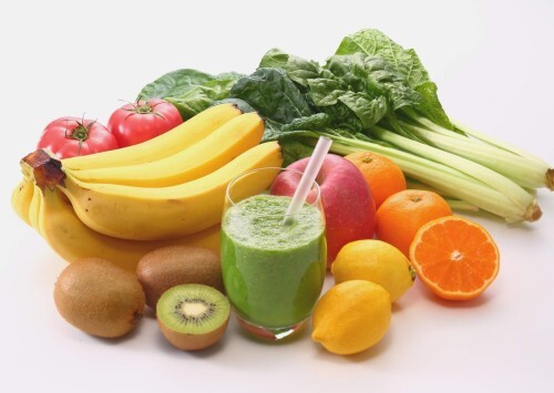 Frisches Obst und Gemüse mit grünem Smoothie. Typische Low-FODMAP-Lebensmittel wie Bananen, Kiwi, Spinat, Tomaten und Zitrusfrüchte.